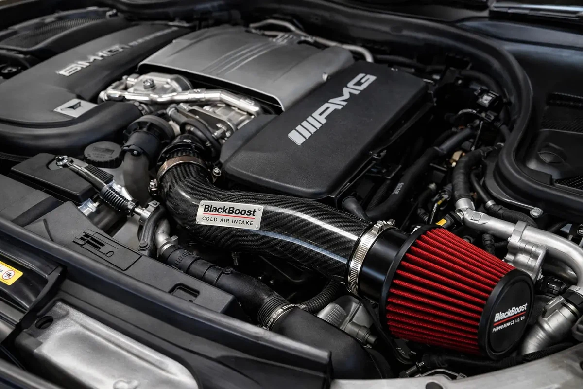 BlackBoost Cold Air Intake eingebaut im Motorraum eines Mercedes-AMG C63 W205 – Ansaugrohr-Führung vom Filter zum Turboeinlass sichtbar